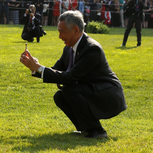 Lee stops to take a picture as he and Obama greet visitors during an official arrival ceremony on the South Lawn of the White House in Washington, U.S.